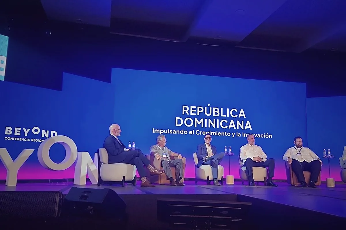 Panel on stage at the regional Beyond conference beneath a screen reading República Dominicana